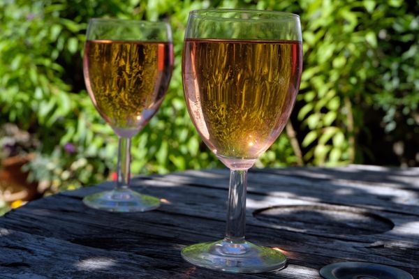 Deux verres de vin rosé sur une table, à l'ombre (Image d'illustration).