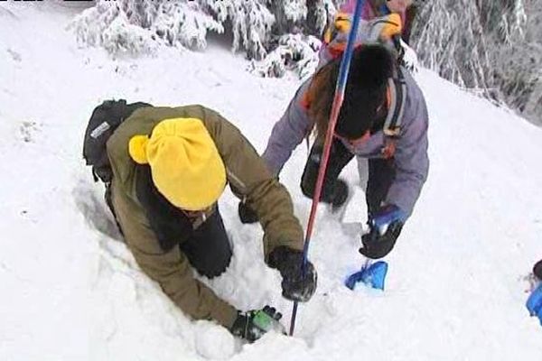 Ce stagiaire a dans les mains un petit boîtier appelé DVA (détecteur de victimes d'avalanches)