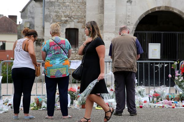 Pendant que l'enquête se poursuit, les hommages fleurissent devant l'église où s'est déroulée l'attaque terroriste perpétrée par deux islamistes, dont l'un, Petitjean, d'origine Vosgienne.