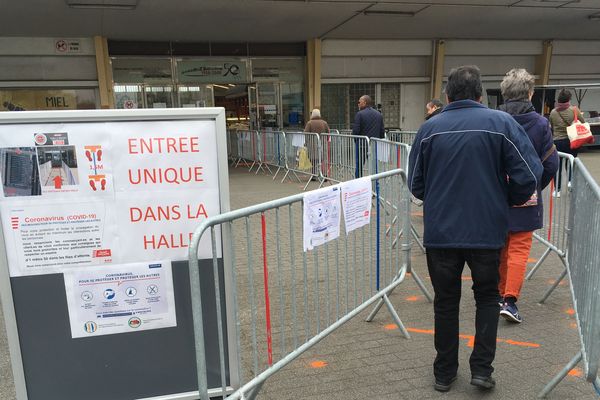 Un couloir unique pour entrer au marché des Halles de Saint-Nazaire et des consignes affichées pour rappeler les règles de comportement dans ce contexte de crise sanitaire