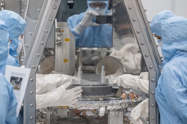 Les membres de l'équipe d'OSIRIS-REx du Johnson Space Center de la NASA commencent le processus de retrait et de retournement du TAGSAM (Touch-and-Go Sample Mechanism).