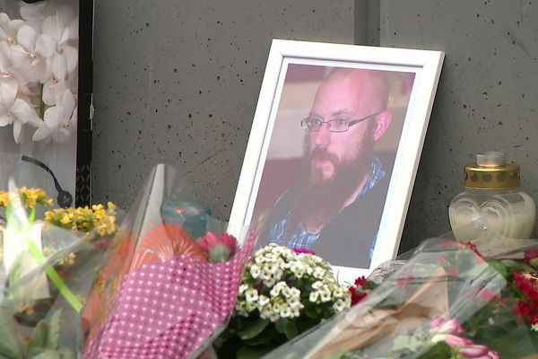 Mardi 14 janvier, devant l'entrée de l'hypermarché, hommage et recueillement devant un portrait de Maxime, 34 ans.