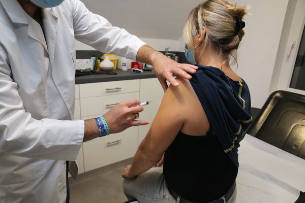Un medecin généraliste vaccine une patiente avec le vaccin grippe. D'ici quelques semaines, les patients pourront se faire vacciner contre la Covid. 