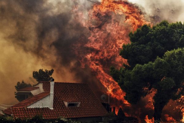  Une maison en flamme, près d'Athènes, le 23 juillet 2018.  