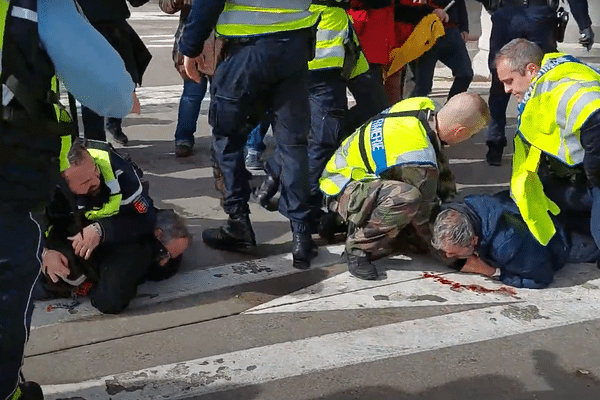 Deux hommes sont au sol, en sang. Plus loin, un autre est également allongé, pris en charge pas des manifestants, mercredi 8 mars au péage du viaduc de Millau (Aveyron).