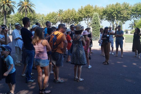 Les visiteurs écoutent avec attention la guide des Légendines raconter l'histoire d'une villa hantée de la place Saint-Nicolas.