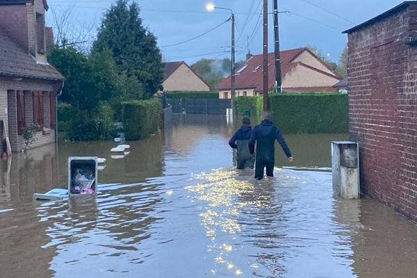 Des riverains tentent d'aller prévenir deux couples pris au piège des eaux à Blendecques, dans le Pas-de-Calais, mardi 7 novembre 2023.