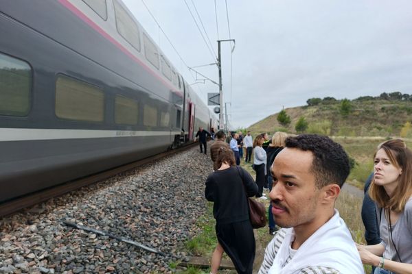 Les voyageurs d'un TGV en panne, attendent au bird de la voie ferrée, près de Comps, à l'est de Nîmes, dans le Gard.