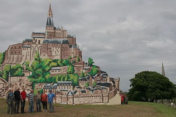 Les bénévoles de Montpinchon (Manche) prennent la pose devant la réplique du Mont-saint-Michel