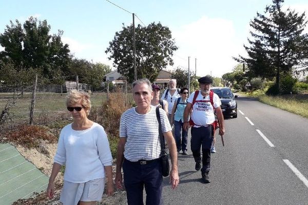 Patrick Maurin, béret sur la tête et bâton de marche,  ce matin accompagnés sur la route par des amis.