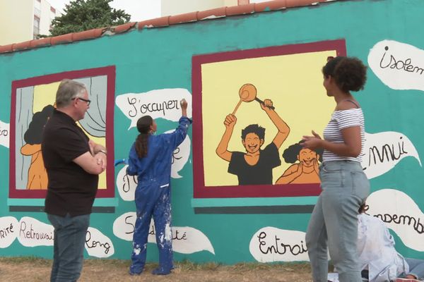 Jean-Luc Dorchies, une jeune artiste en herbe de la Gibauderie et Khassatu Ba devant la peinture murale ce vendredi 31 juillet.