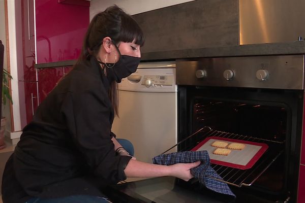 Dans sa cuisine, Emilie confectionne des biscuits personnalisés qu'elle vend sur internet.