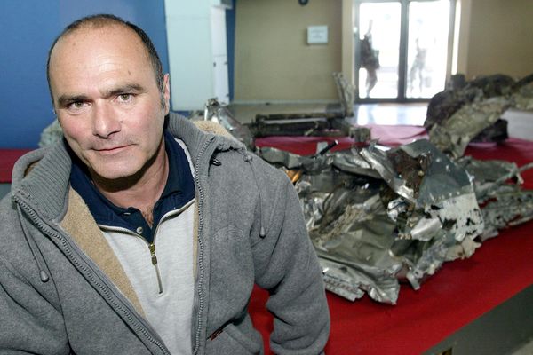 Le plongeur marseillais Luc Vanrell qui a découvert l'avion d'Antoine Saint-Exupéry pose, le 9 avril 2004 à la base aérienne d'Istres, près des morceaux du Lightning P38 retrouvés au large de Marseille à l'automne 2003.