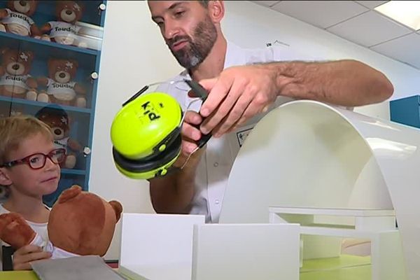 Avec la peluche Toudou et une IRM miniature, le manipulateur en radiologie Gauthier Binninger explique à Nathan, 6 ans, les différentes étapes de cet examen quelque peu anxiogène.