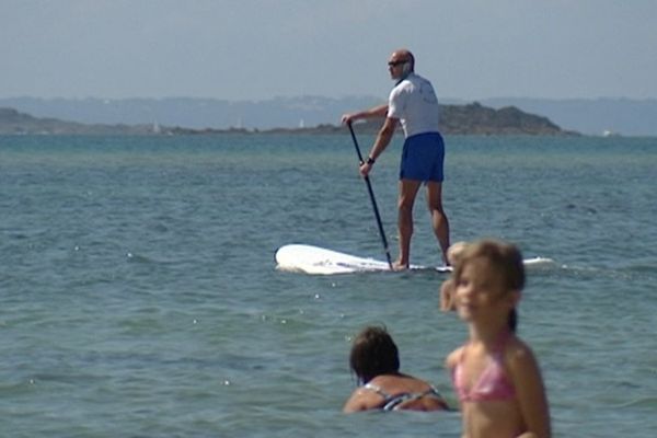 Le CRS debout sur sa planche glisse sur l'eau