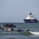 Des migrants nagent pour monter à bord d'un bateau de passeurs au large de la plage d'Audresselles (62), le 25 octobre 2024.