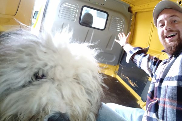 Manu Auguste et Joke, sa mascotte canine, dans le camion qu'il veut aménager en ludothèque pour faire jouer les villages des campagnes picardes.