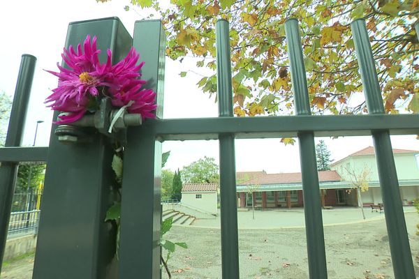 Des fleurs ont été déposées sur la grille de l'établissement où a été retrouvé le corps sans vie d'une enseignante.