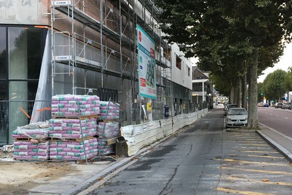 Matériaux empilés derrière une fine grille sur un chantier en cours avenue du Mont-Riboudet à Rouen en septembre 2019. 