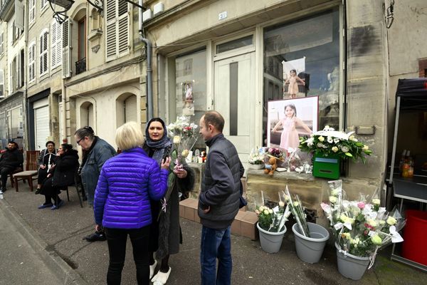 Des habitants de la commune viennent déposer des fleurs devant le domicile des parents de la petite Rose-Izabela.