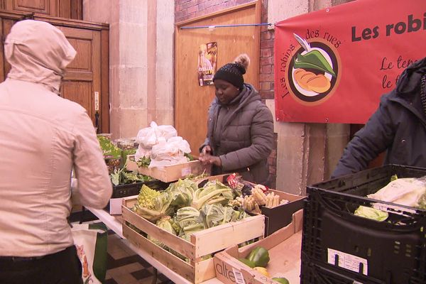 Les bénévoles distribuent la nourriture dans le hall de l'église Saint Léger