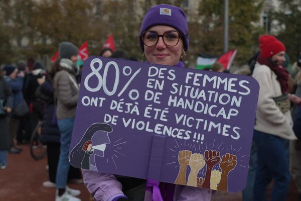 Manifestation contre les féminicides et les violences faîtes aux femmes. Amandine participe à la manifestation. La jeune femme travaille auprès d'un public en situation de handicap. Sur sa pancarte, un chiffre alarmant.