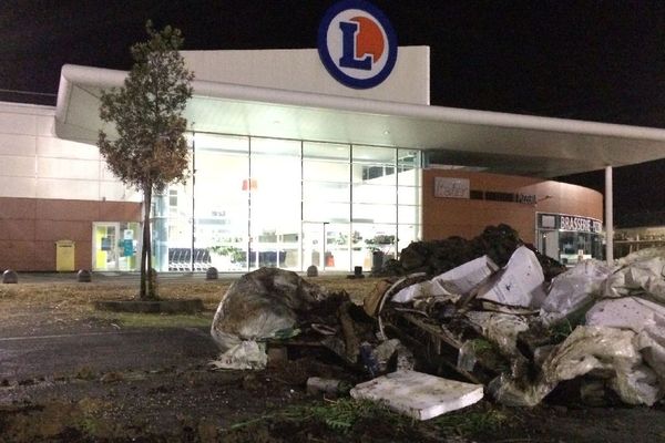 Déchets déversés sur le parking d'une grande surface