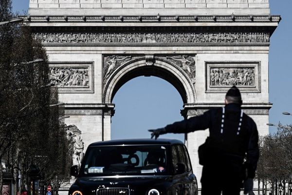 Un policier contrôle une voiture dans le cadre du confinement contre la propagation du coronavirus, le 23 mars aux abords de l’Arc de Triomphe à Paris (illustration).