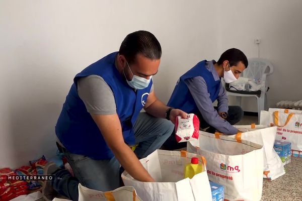 Des membres de l'association "Un sourire pour tous" préparent des paniers repas