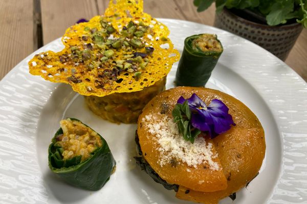 Une délicieuse tatin de butternut accompagnée de sushis au cari de légumes enroulés dans des feuilles de blettes et d'une tuile à la pistache