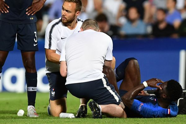 Jonathan Bamba allongé sur la pelouse après avoir reçu un violent tacle anglais.