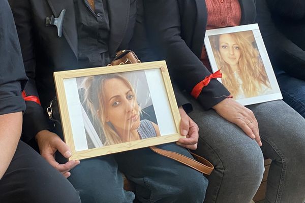 Deux portraits de la victime, Coralie Kempf, sont tenus par des membres de sa famille.