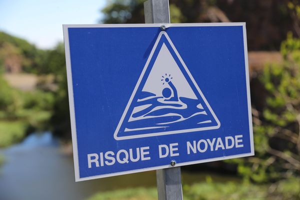 Un panneau "risque de noyade" au bord d'un lac - Photo d'illustration