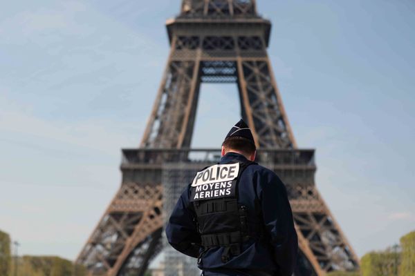 Un policier patrouille à proximité de la tour Eiffel, à Paris.