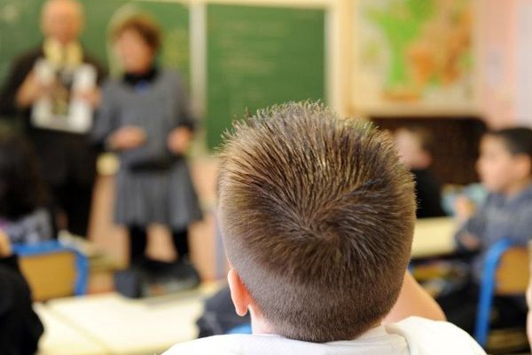 Des enfants d'une classe primaire écoutent un cours de sensibilisation sur les poux.