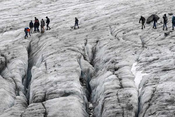 Août 2018, un guide accompagne un groupe à proximité des crevasses sur le glacier de Val Thorens dans les Alpes
