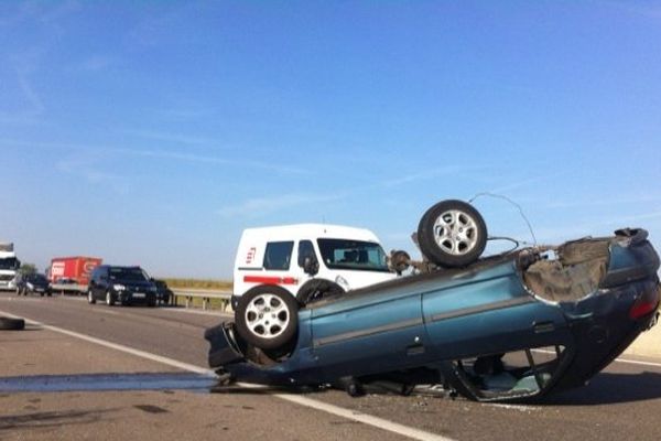 Le véhicule accidenté reposant sur le toit après vraisemblablement plusieurs tonneaux.