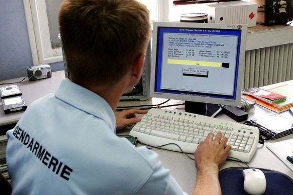 Un gendarme de la cellule "cybercriminalité" copie le disque dur d'un ordinateur afin d'en vérifier le contenu, le 16 septembre 2005 à Lille.