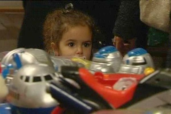 Une petite fille regarde les jouets lors de la grande vente d'automne Emmaüs d'Alençon (8 novembre 2014)