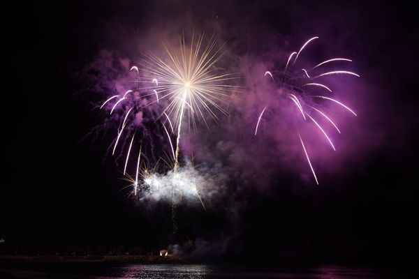 Le reflet des feux d'artifice est visible dans la mer.