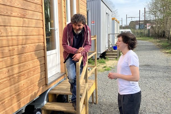 Sur le pas de porte de sa "tiny", Abder l'un des actuels résidents, discute avec Justine, monitrice-éducatrice à "La Maison"