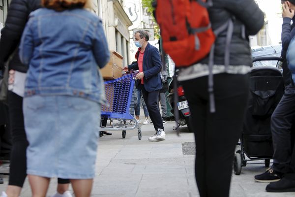 Des bénéficiaires du Secours Populaire font la queue sur le trottoir de la rue vernier à Nice, le 3 mai 2020.