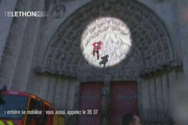 Un pompier descend en rappel la cathédrale de Sens pour le Téléthon 2014.