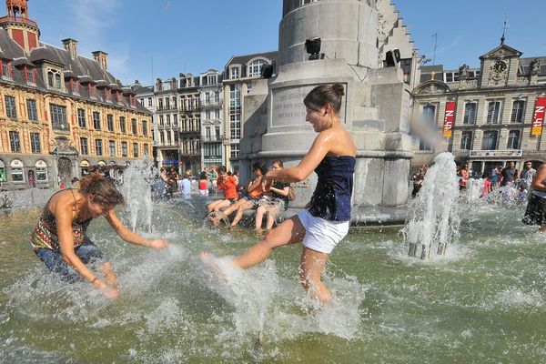 Des personnes se rafraichissent sur la Grand Place de Lille, il est 18 heures et le thermomètre affiche 39 degrés au soleil. C'était le 26 juin 2011. 
