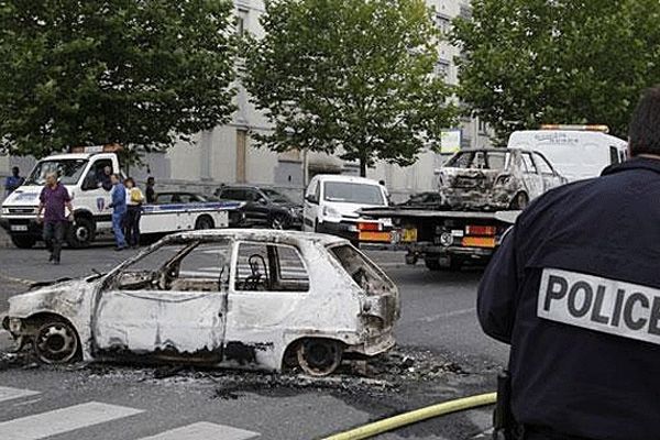 La police enlève des voitures brûlées lors d'affrontements survenus dans la nuit du 13 au 14 août dans le quartier nord d'Amiens.