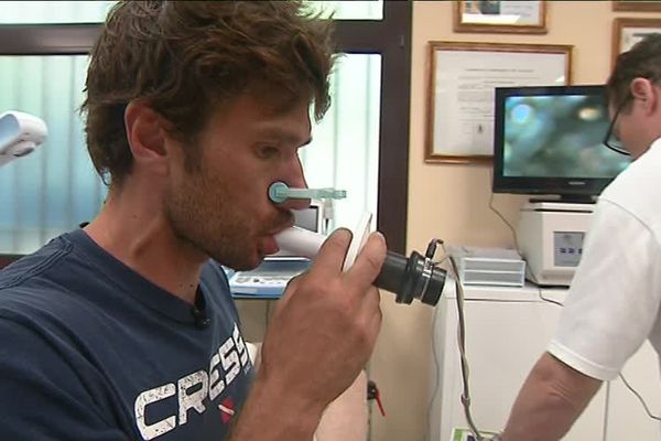 Le champion du monde d'apnée, Guillaume Néry cherche à améliorer sa capacité pulmonaire en soufflant dans cet embout