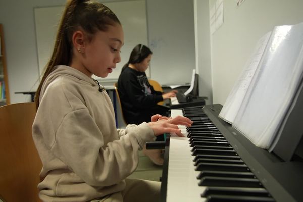 Certains collégiens jouent pour la toute première fois au piano, à l'école.