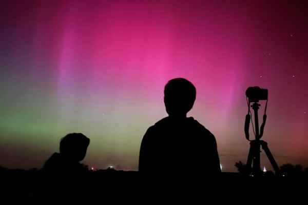 Des photographes devant les aurores boréales observées depuis les Sables d'Olonne en Vendée dans la nuit du 10 au 11 mai 2024