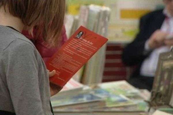 Une jeune lectrice dans les allées du festival du livre de jeunesse de Rouen en 2012