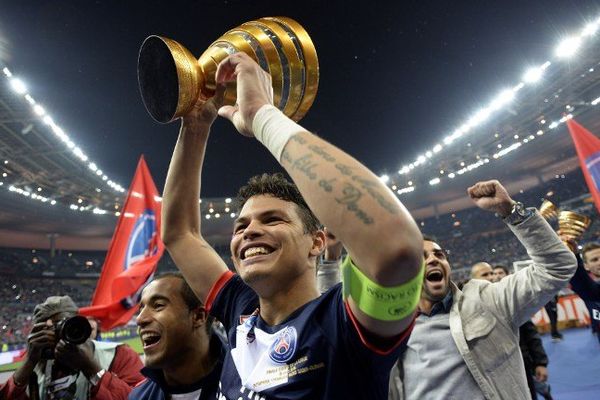 Le capitaine du PSG, le Brésilien Thiago Silva, soulève la coupe de la Ligue après la victoire des Parisiens sur l'Olympique Lyonnais, au stade de France, en finale le 19 avril 2014 (2-1)